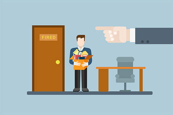 Employee in business attire stands with folders beside a door labeled 'FIRED' as a large pointing hand looms to the right, indicating termination.