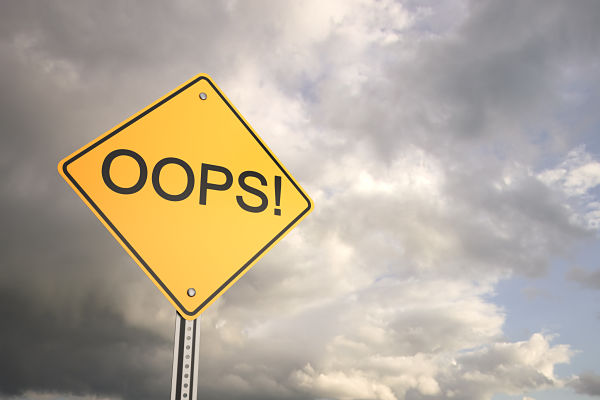 Yellow diamond warning sign reading 'OOPS!' against a cloudy sky behind it.