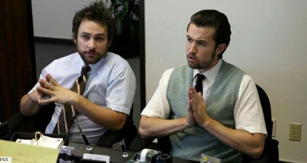 Two men sitting at their desk with their hands clasped together
