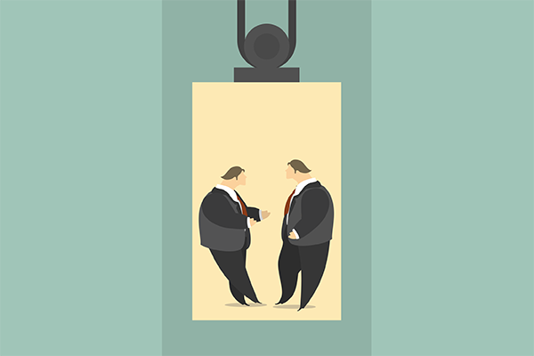 Two suited businessmen facing each other, one extending a handshake as a sign of a business agreement.